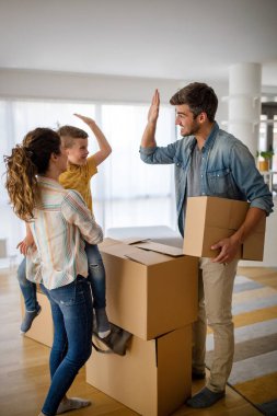 Aile yeni evinde karton kutuları açıyor. Yeni ev, aile, sigorta konsepti.
