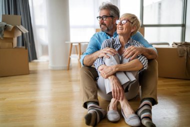 Mutlu, olgun bir çift evde birbirine sarılıyor ve gerçek duygularla kaynaşıyor.