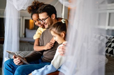 Çok ırklı çocuklar ve babalar çevrimiçi okul için evde okuyor.