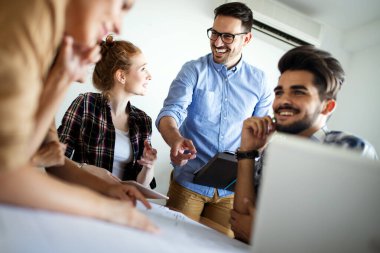 Ofisteki iş arkadaşlarıyla birlikte çalışırken analitik rapor sunan başarılı iş adamları