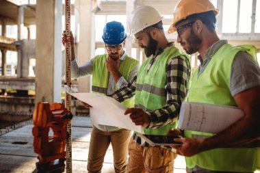 İnşaat mühendislerinden oluşan bir ekip inşaat alanında birlikte çalışıyor.