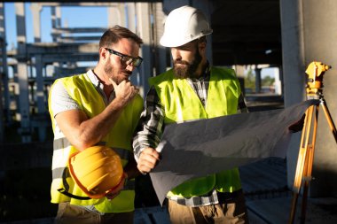 İnşaat mühendislerinden oluşan bir ekip inşaat alanında birlikte çalışıyor.