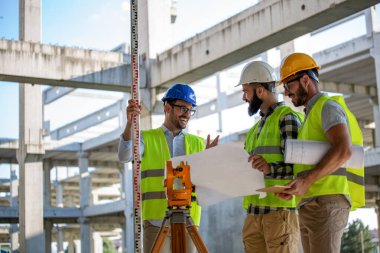 İnşaat mühendislerinden oluşan bir ekip inşaat alanında birlikte çalışıyor.