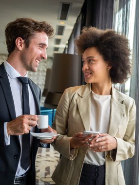 Kahve molası sırasında sohbet eden genç, mutlu profesyoneller.