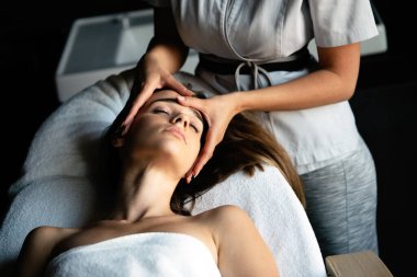 Masaj masasında uzanan ve masajdan zevk alan genç bir kadın..