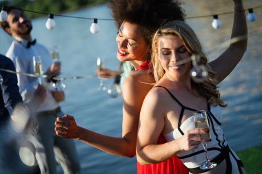 Bir grup arkadaş içiyorlar, dans ediyorlar ve dışarıda eğleniyorlar.