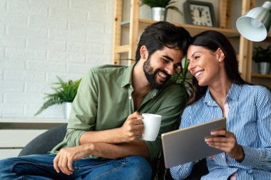 Oturma odalarında tablet bilgisayar kullanan aşık bir çift. Birlikte boş zaman..