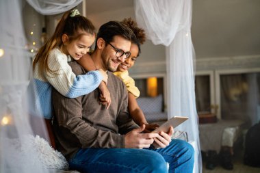 Çok ırklı çocuklar ve babalar çevrimiçi okul için evde okuyor.