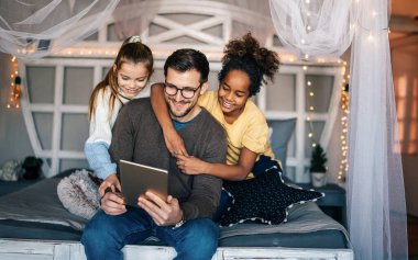 Çok ırklı çocuklar ve babalar çevrimiçi okul için evde okuyor.