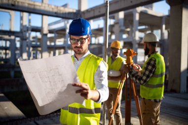 İnşaat mühendislerinden oluşan bir ekip inşaat alanında birlikte çalışıyor.