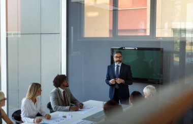Harika kararlar veriyor. Mutlu başarılı iş adamları, toplantıda birlikte beyin fırtınası yapıyorlar.
