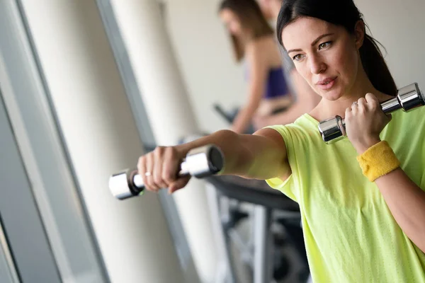 Spor Salonunda Dambıllarla Çalışan Çekici Bir Kadın — Stok fotoğraf