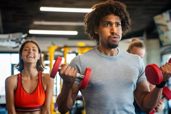 Happy fit people exercising, working out in gym to stay healthy together