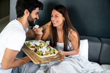 Mutlu adam kahvaltıyı yatağındaki güzel kız arkadaşına getiriyor.