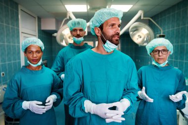 Başarılı bir tıbbi cerrah ekibinin portresi ameliyathanede, hastanede çalışmaya hazır.