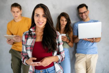 Dijital cihazlar kullanarak çalışan neşeli gençler. Teknoloji, insanlar konsepti.