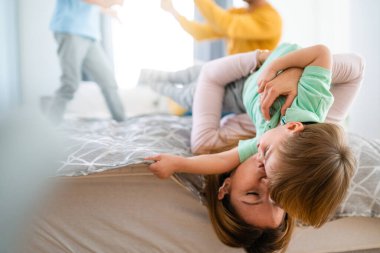 Neşeli çocuk eğleniyor, annesiyle birlikte evde oyun oynuyor. Tek ebeveynlik, mutluluk, çocukluk kavramı.
