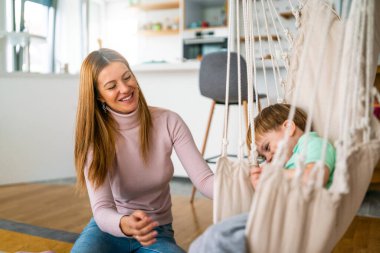 Neşeli çocuk eğleniyor, annesiyle birlikte evde oyun oynuyor. Tek ebeveynlik, mutluluk, çocukluk kavramı.