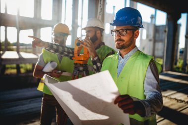 Takım mühendisi ve mimarları yeni bir proje planlamak için toplanıyorlar. İnşaat alanı planlama kavramını tartışıyor