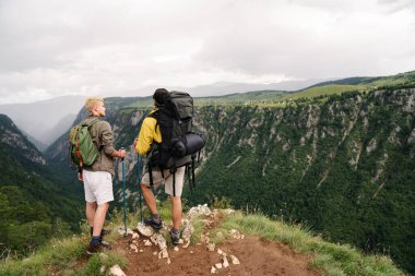 Sırt çantalı bir grup arkadaş dağda yürüyüş yapıyor. Trekker, spor, yürüyüş ve seyahat konsepti