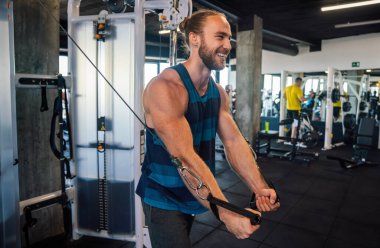 Spor salonunda egzersiz yapan kendine güvenen genç bir adam.