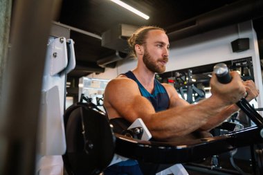 Spor salonunda çalışan sağlıklı genç bir adam.