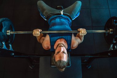 Yakışıklı, kaslı, fit adam spor salonunda sıkı çalışıyor.