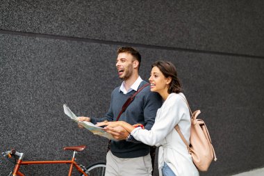 Mutlu genç gezginler haritayı ellerinde tutuyorlar.