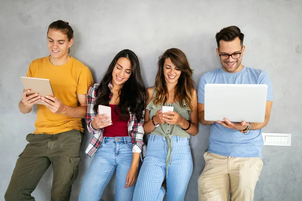 Dijital cihazlar kullanarak çalışan neşeli gençler. Teknoloji, insanlar konsepti.