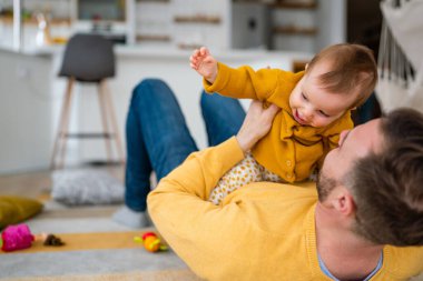 Baba ve kızı gülüyor ve kaynaşıyorlar. Babası ve küçük kızı evde vakit geçiriyorlar. Bekar baba eğlence aile hayatı kavramını sever.