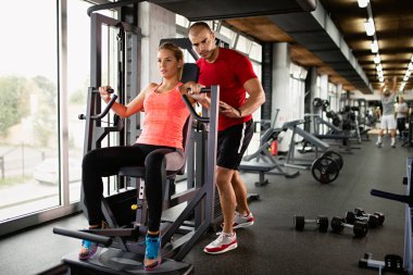 Formda bir kadına spor salonunda yardımcı olan kişisel antrenör. Spor insanları sağlıklı yaşam tarzı konsepti