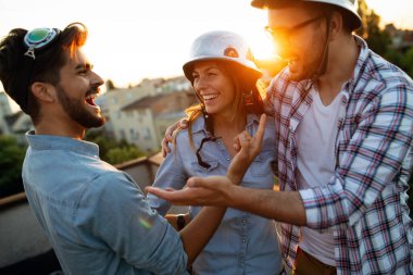 Mutlu neşeli arkadaşlar birlikte dışarıda eğleniyorlar.