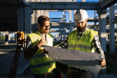 İnşaat mühendislerinden oluşan bir ekip inşaat alanında birlikte çalışıyor.