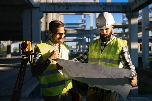 İnşaat mühendislerinden oluşan bir ekip inşaat alanında birlikte çalışıyor.