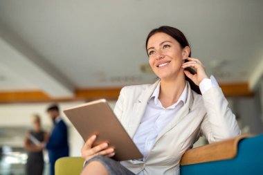 Ofiste dijital tablet kullanan çekici bir iş kadını. Halkın iş teknolojisi kavramı