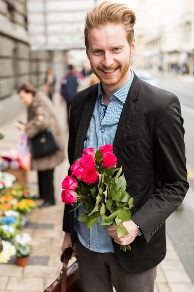 Empresario sosteniendo rosas — Foto de Stock