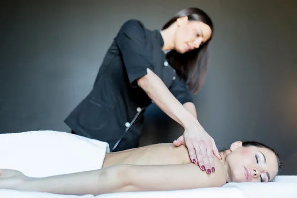 Massagista massageando uma senhora deslumbrante — Fotografia de Stock