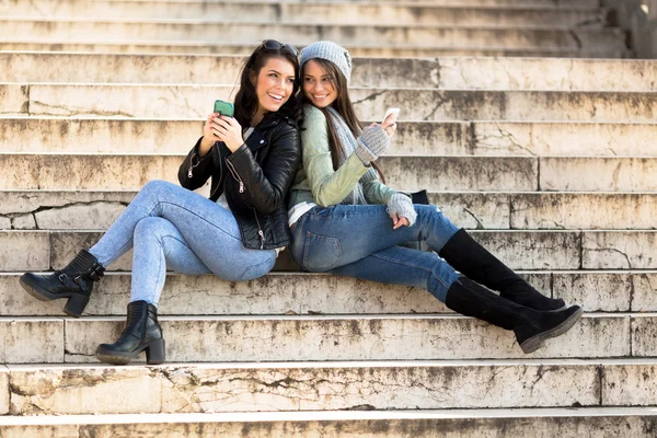 Women leaning against each other on stairs — Stock Photo, Image