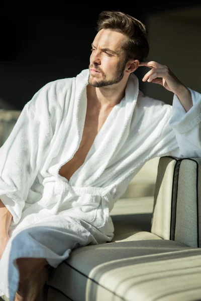 Healthy male in a robe relaxing on a couch — Stock Photo, Image