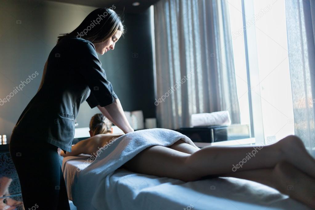 Young massage therapist massaging client