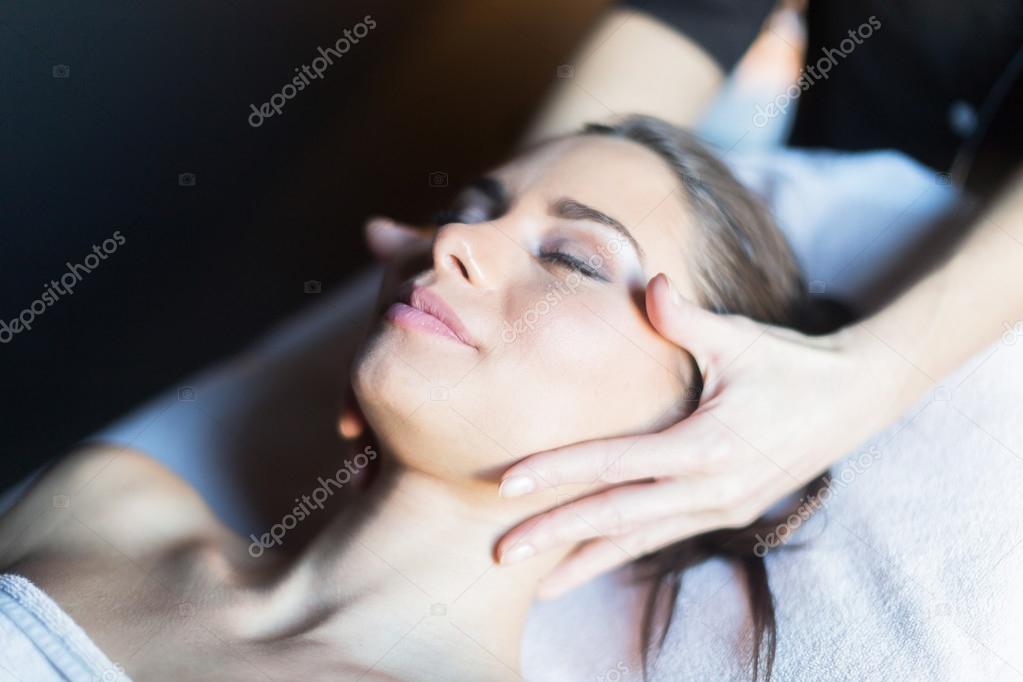 Masseur massaging face of woman