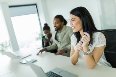 meslektaşları ile bir ofis masa başında oturan işkadını
