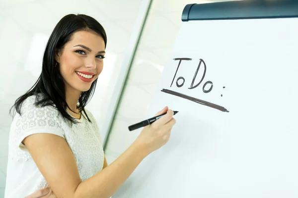 Geschäftsfrau schreibt Todo auf eine Schreibtafel — Stockfoto