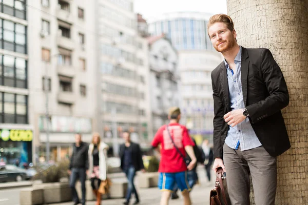 Empresario en una ciudad ocupada sonriendo — Foto de Stock