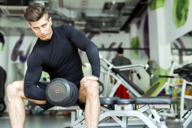 Adam spor salonunda antrenman yapıyor.