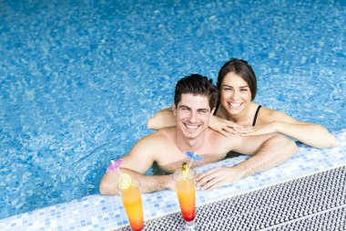 Yüzme havuzun kenarında bir kokteyl içme Çift
