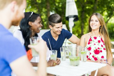 Mutlu arkadaş oturan bir masada konuşurken