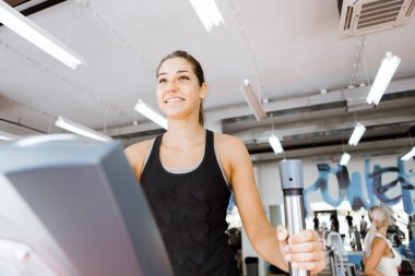 Eliptik bir eğitmen kullanan kadın