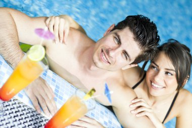 Yüzme havuzun kenarında bir kokteyl içme Çift