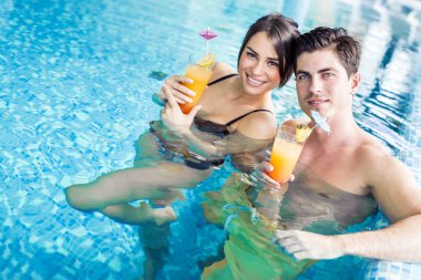 Yüzme havuzun kenarında bir kokteyl içme Çift